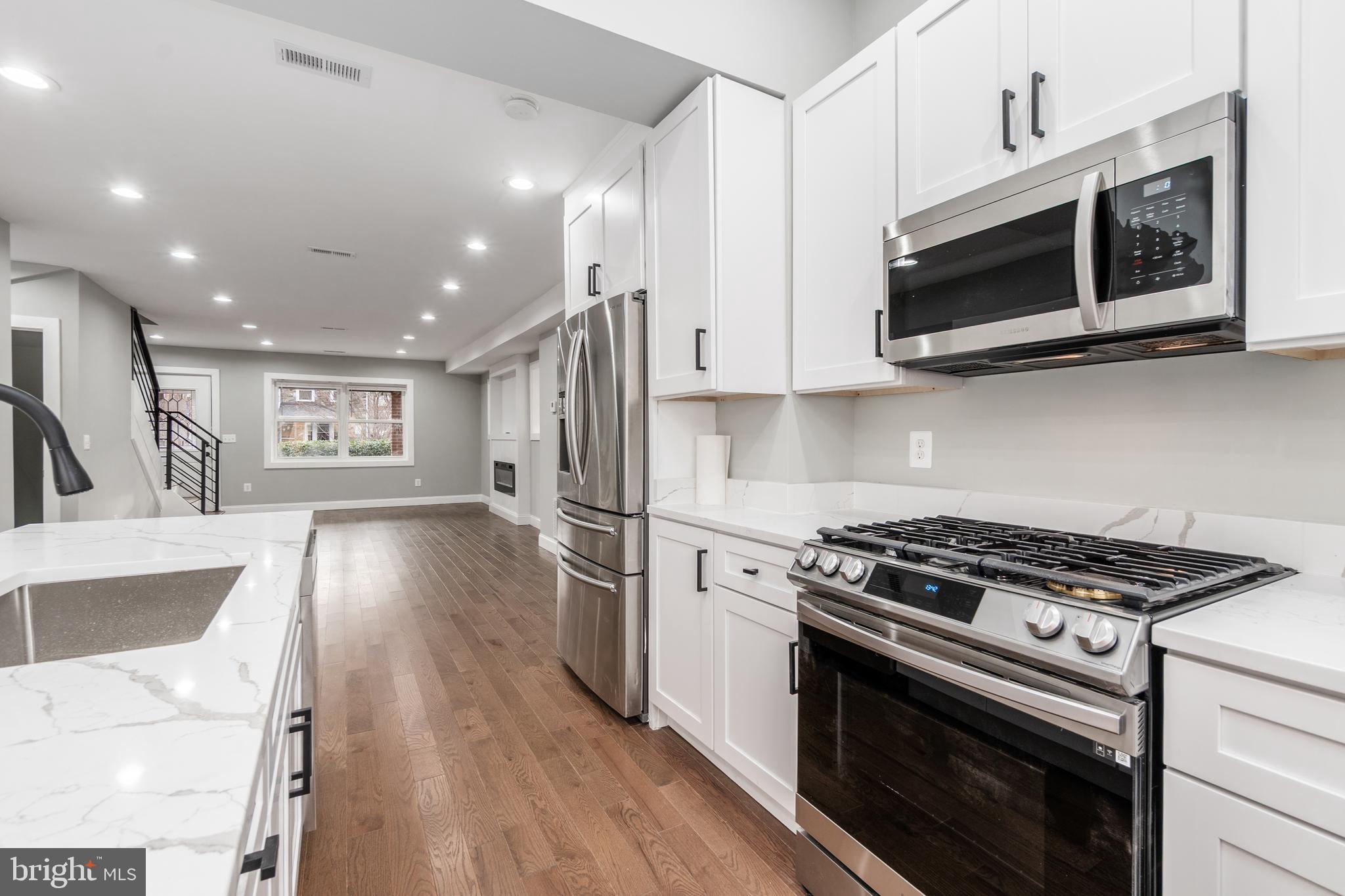 928 Perry Place Northeast Washington, DC 20017 - Photo 11 of 36 a kitchen with stainless steel appliances a stove a microwave and cabinets
