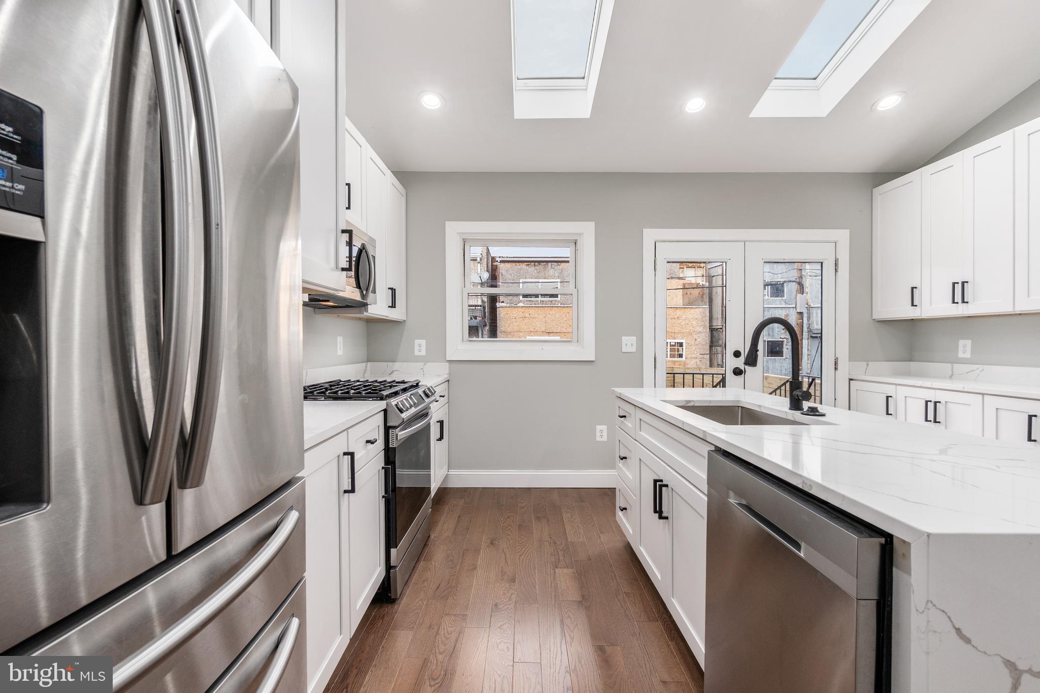 928 Perry Place Northeast Washington, DC 20017 - Photo 12 of 36 a kitchen with stainless steel appliances granite countertop a sink stove and refrigerator