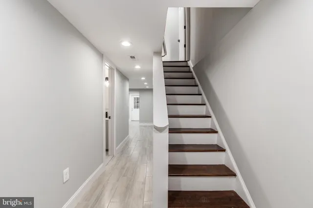 a view of a hallway with wooden floor and staircase