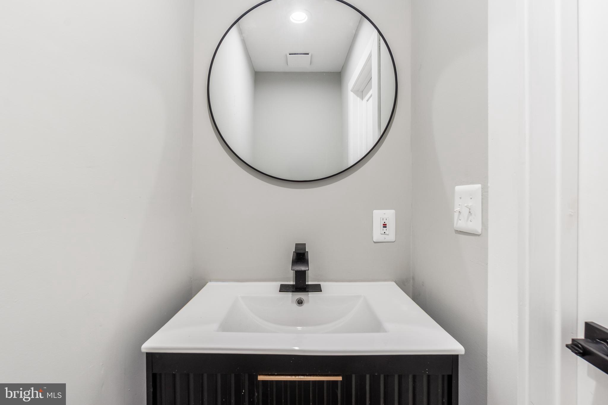 928 Perry Place Northeast Washington, DC 20017 - Photo 16 of 36 a bathroom with a sink and a mirror