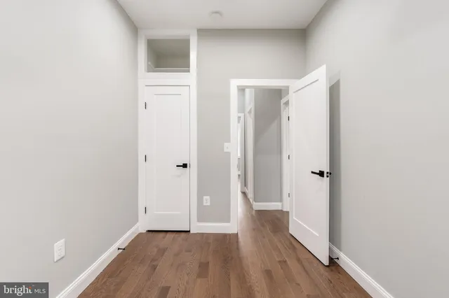 a view of a big room with wooden floor and windows