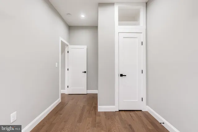 a view of hallway with granite countertop cabinets and wooden floor
