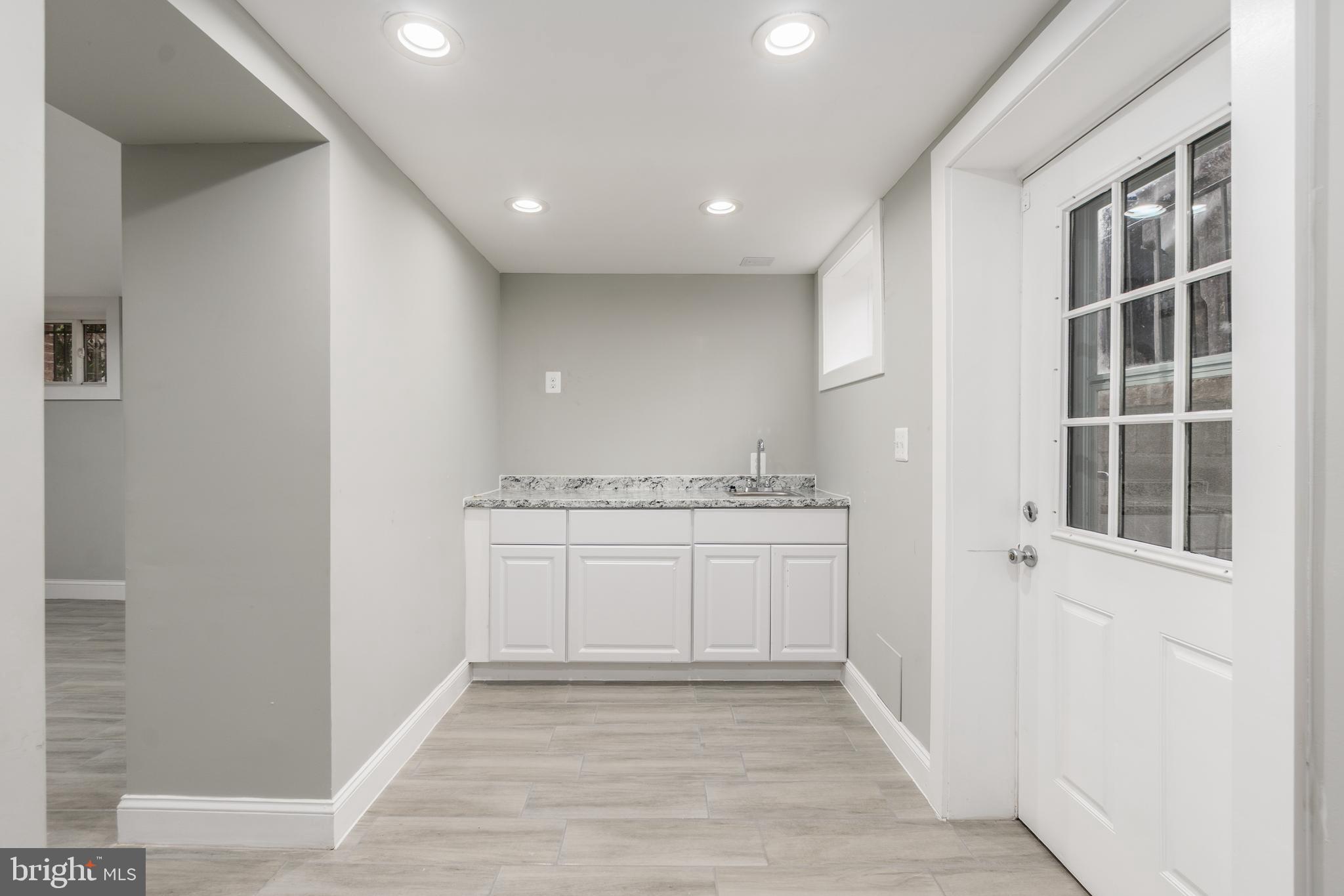 928 Perry Place Northeast Washington, DC 20017 - Photo 26 of 36 a view of hallway with granite countertop cabinets and wooden floor