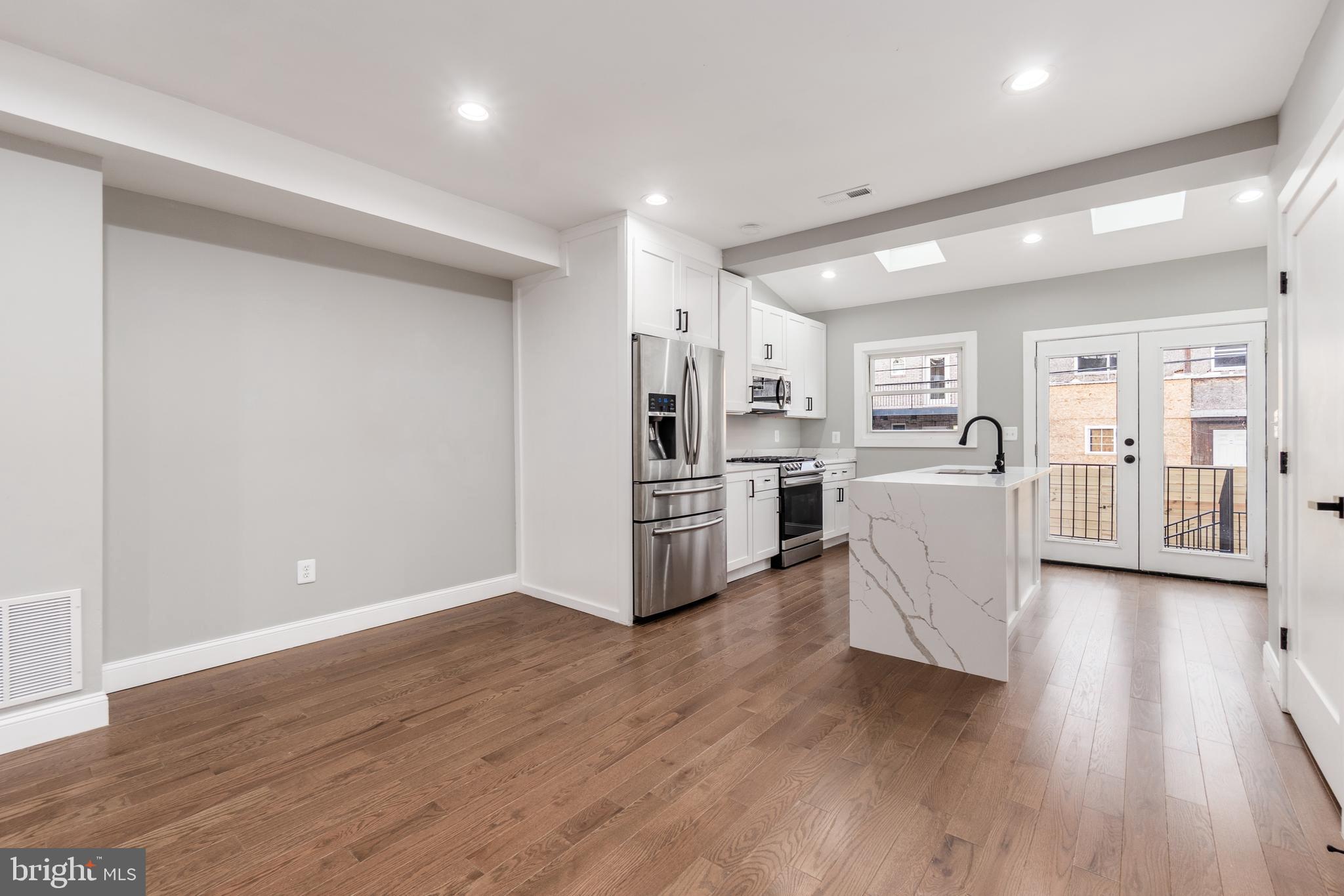928 Perry Place Northeast Washington, DC 20017 - Photo 9 of 36 a living room with stainless steel appliances kitchen island wooden floors and center island