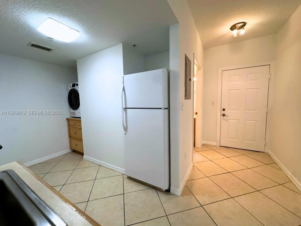 2630 Southwest 28th Street, Unit 44 Miami, FL 33133 - Photo 5 of 12 a kitchen with a refrigerator and cabinets