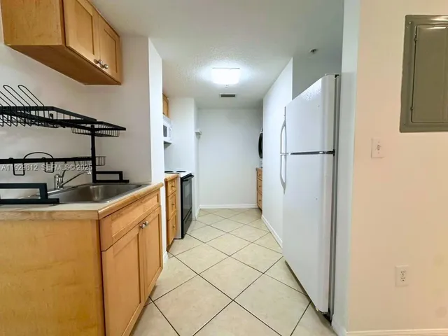 a kitchen with sink a refrigerator and cabinets