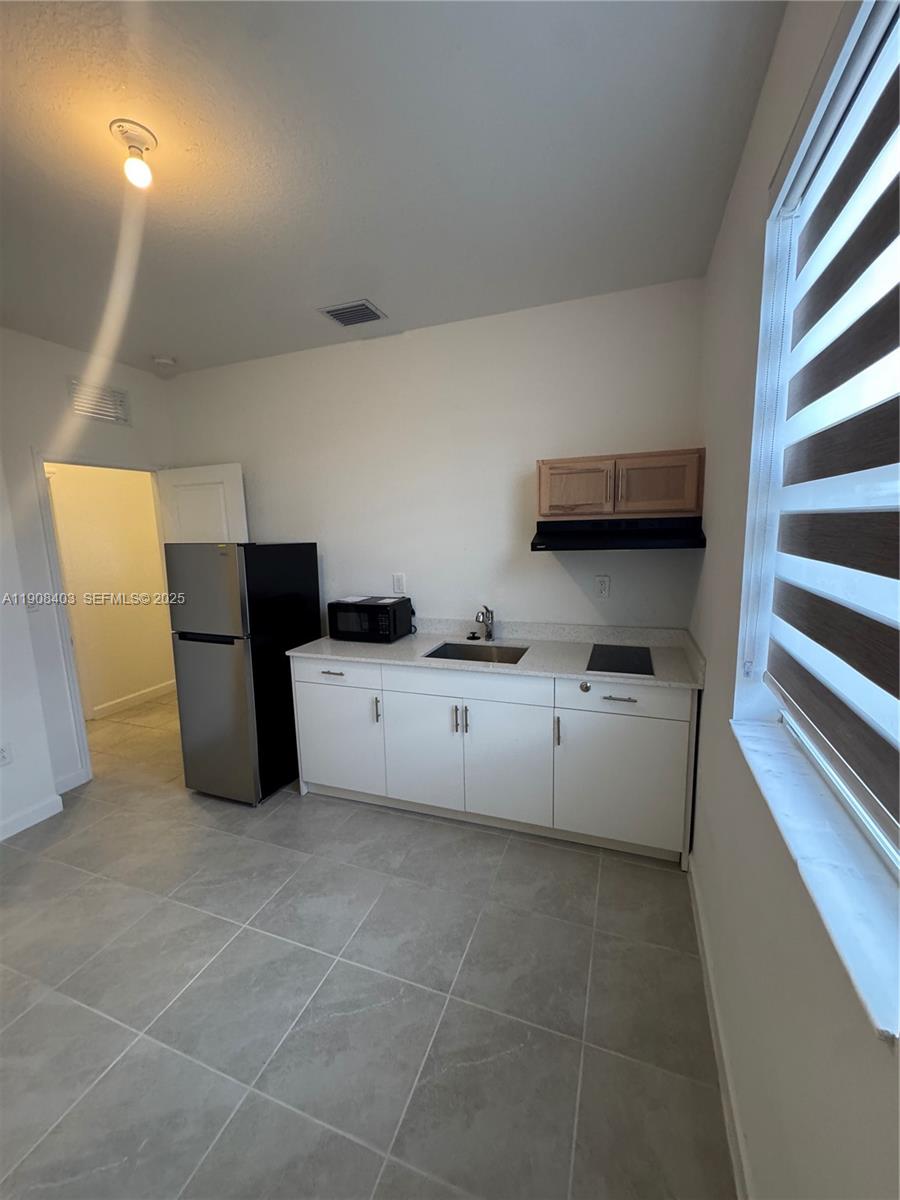 28850 Southwest 163rd Avenue, Unit 2 Homestead, FL 33033 - Photo 14 of 16 a kitchen with granite countertop a refrigerator and a stove
