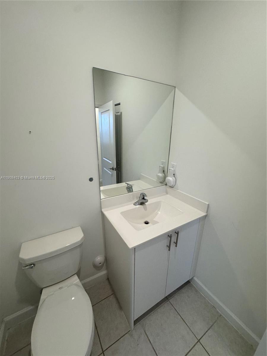 28850 Southwest 163rd Avenue, Unit 2 Homestead, FL 33033 - Photo 8 of 16 a bathroom with a toilet sink and mirror