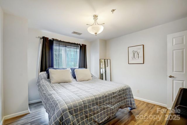 a bedroom with a large bed and a chandelier
