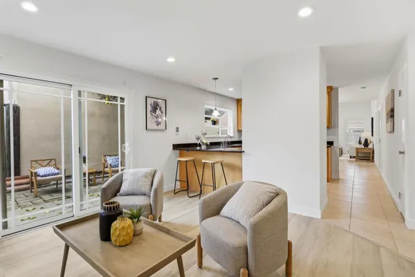 a living room with furniture and a view of kitchen