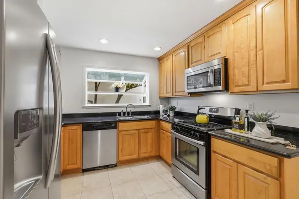 a kitchen with stainless steel appliances granite countertop a stove a sink and a microwave