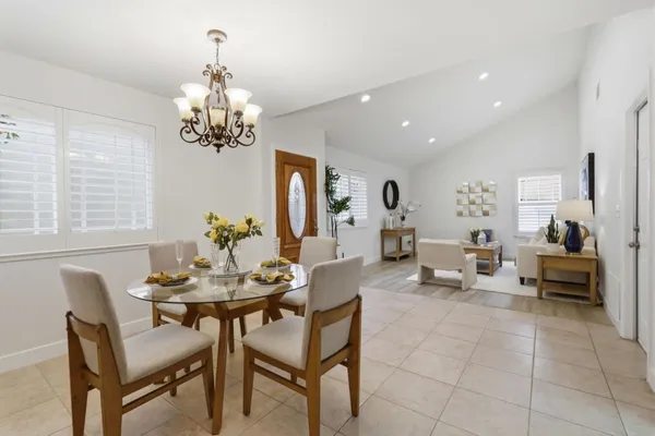a view of a dining room with furniture a livingroom and chandelier