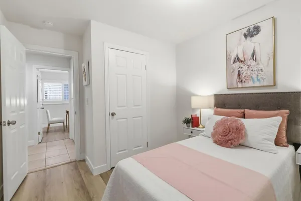 a bedroom with a bed and a painting on the wall