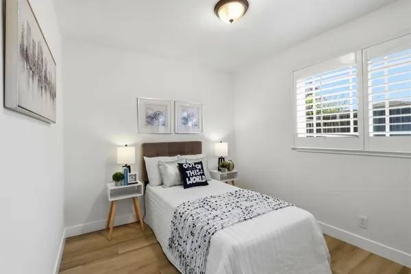 a bedroom with a bed and wooden floor