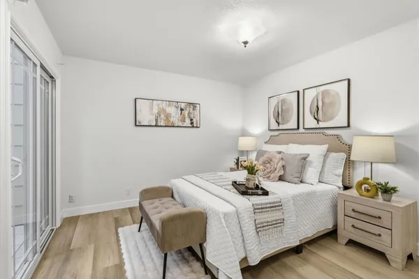 a bedroom with a bed and a lamp on dresser