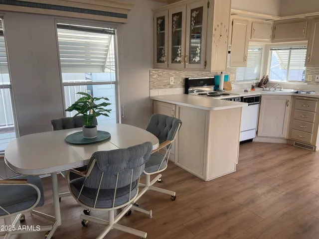 a kitchen with stainless steel appliances granite countertop a stove a sink a microwave dining table and chairs