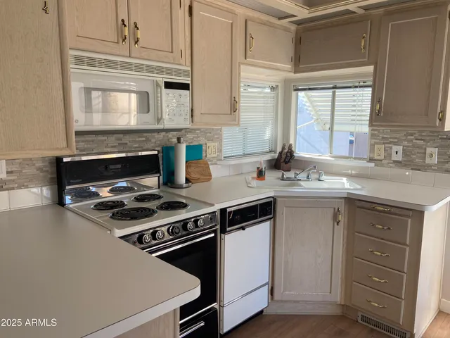 a kitchen with granite countertop a stove sink and cabinets