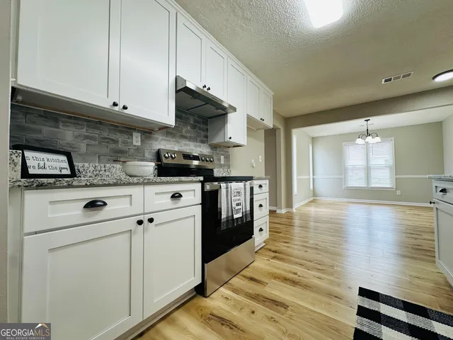 a kitchen with stainless steel appliances white cabinets and a refrigerator