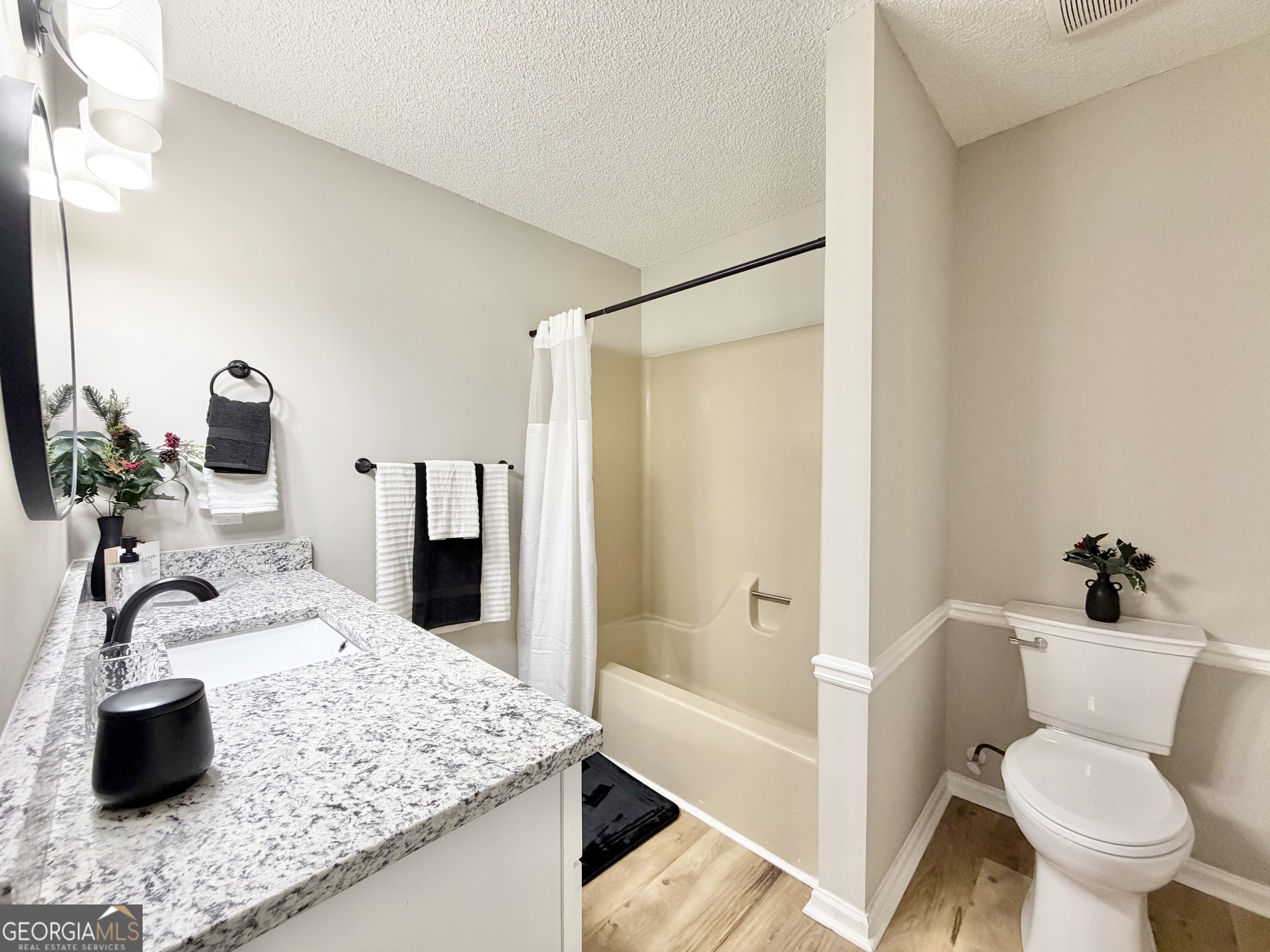1610 Lance Drive Dublin, GA 31021 - Photo 33 of 46 a bathroom with a granite countertop sink a toilet a mirror and shower