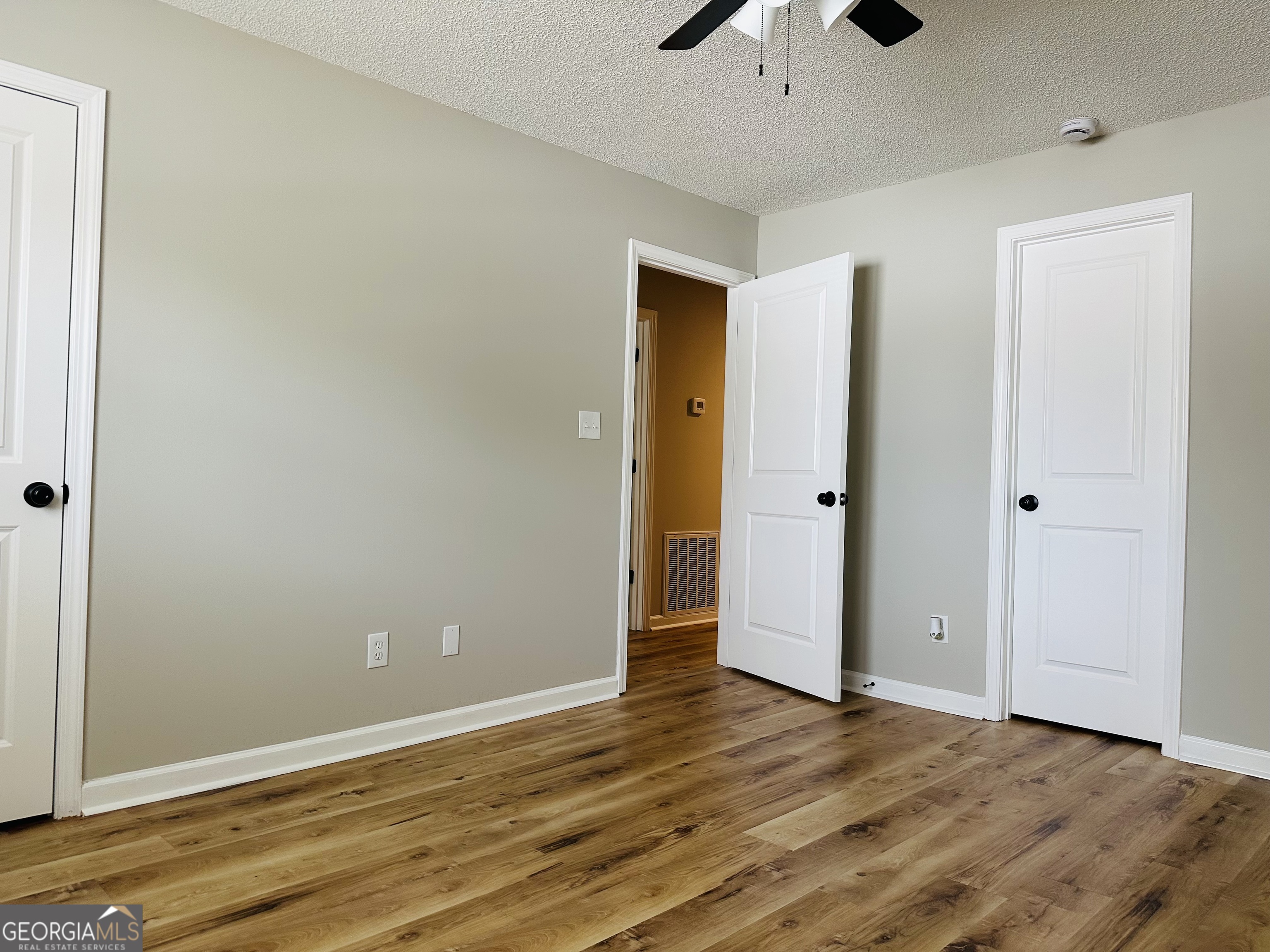 1610 Lance Drive Dublin, GA 31021 - Photo 41 of 46 an empty room with wooden floor and chandelier fan
