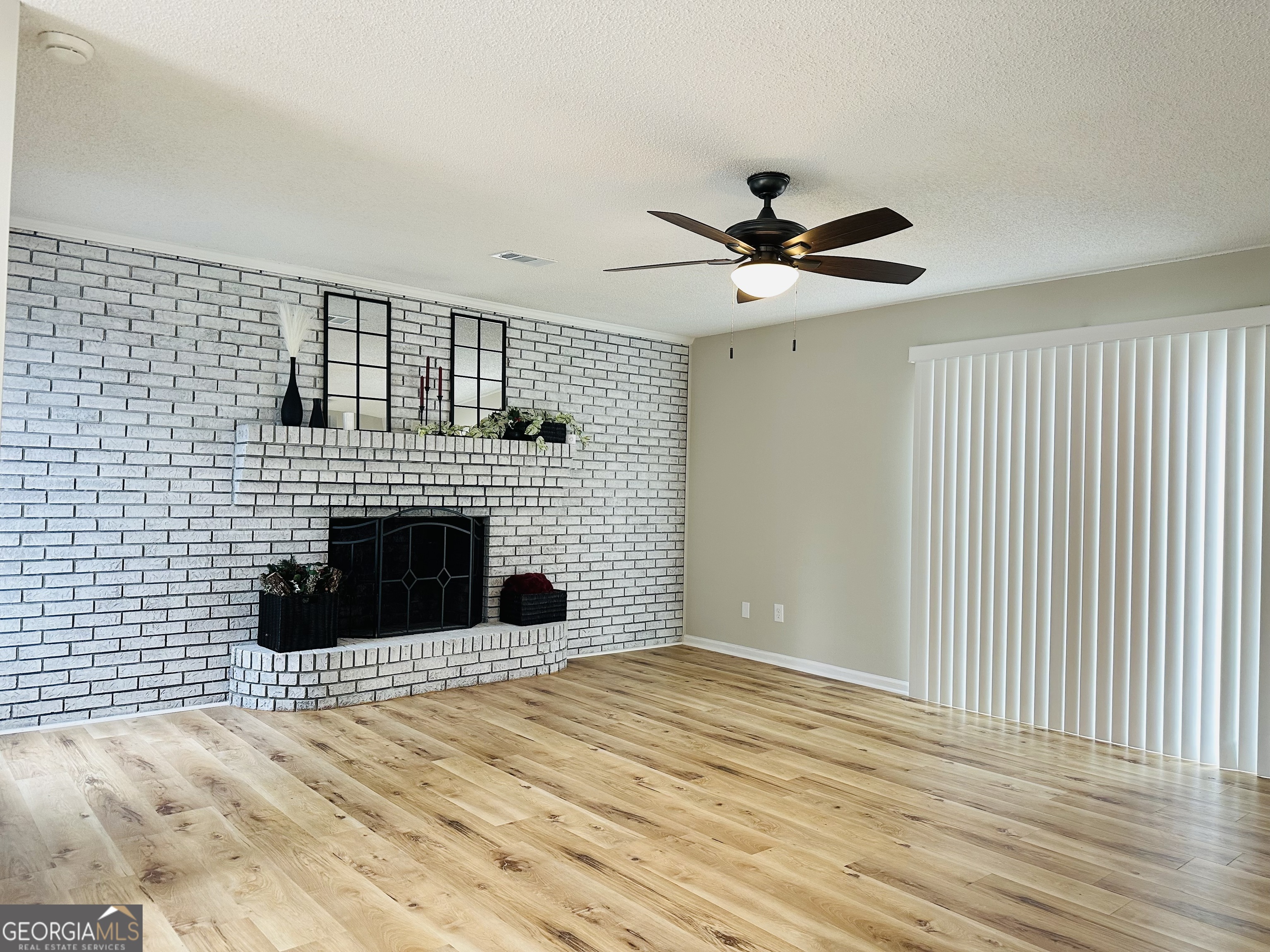 1610 Lance Drive Dublin, GA 31021 - Photo 7 of 46 a view of a livingroom with a ceiling fan a fireplace and a large window