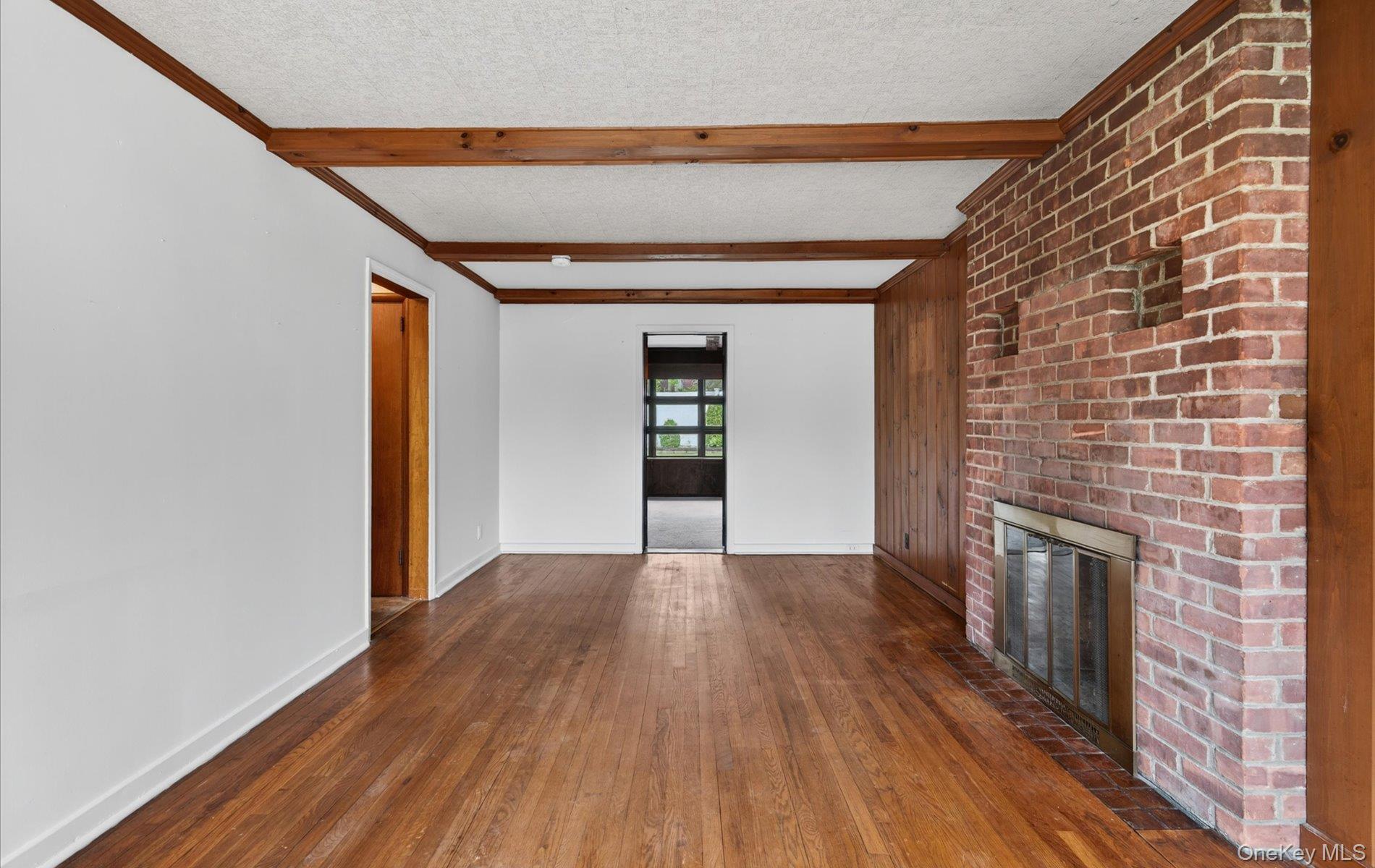 24 Purdue Road Glen Cove, NY 11542 - Photo 10 of 41 a view of empty room with wooden floor and fireplace