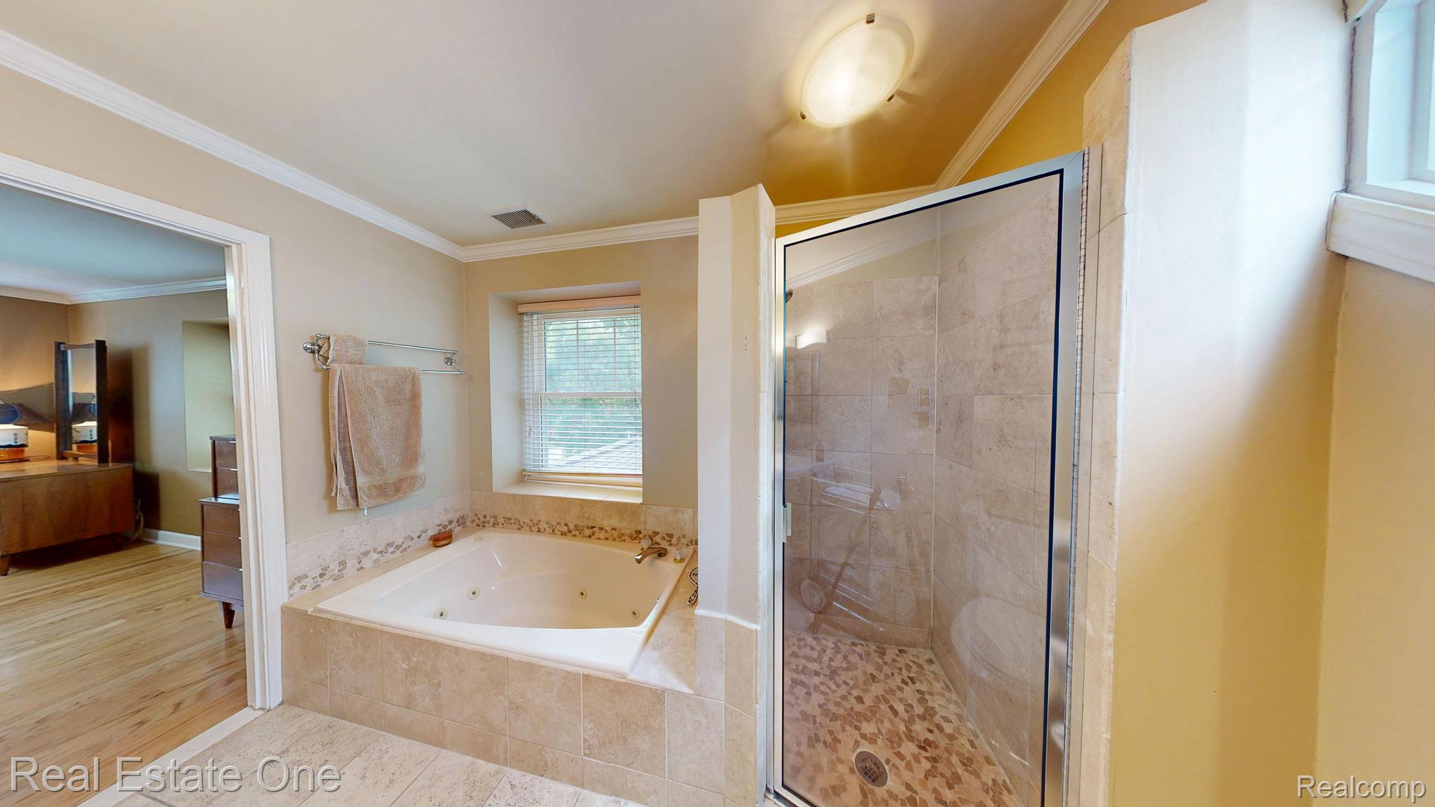 410 West 4th Street Rochester, MI 48307 - Photo 23 of 33 Tiled soaking tub featuring a decorative tile surround and window