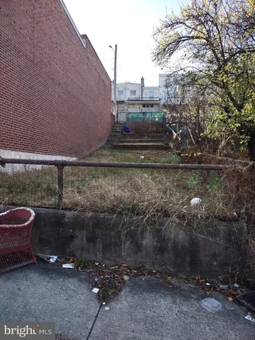 a view of a back yard of the house and cars parked on road