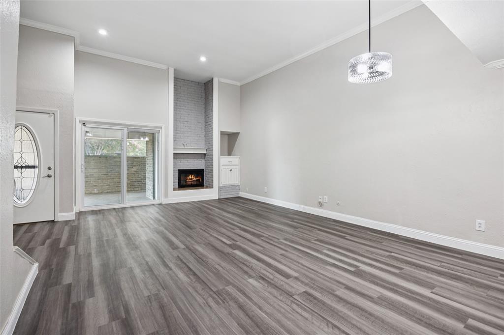 207 East Harwood Road, Unit 14 Euless, TX 76039 - Photo 11 of 28 an empty room with wooden floor fireplace and windows