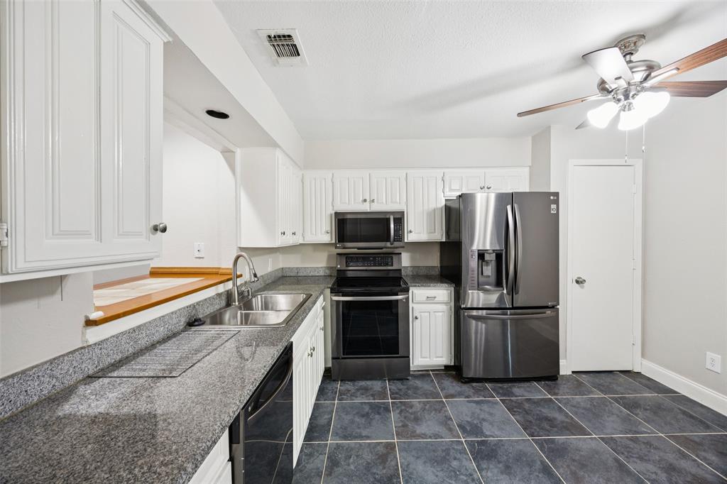 207 East Harwood Road, Unit 14 Euless, TX 76039 - Photo 13 of 28 a kitchen with granite countertop a refrigerator and a sink