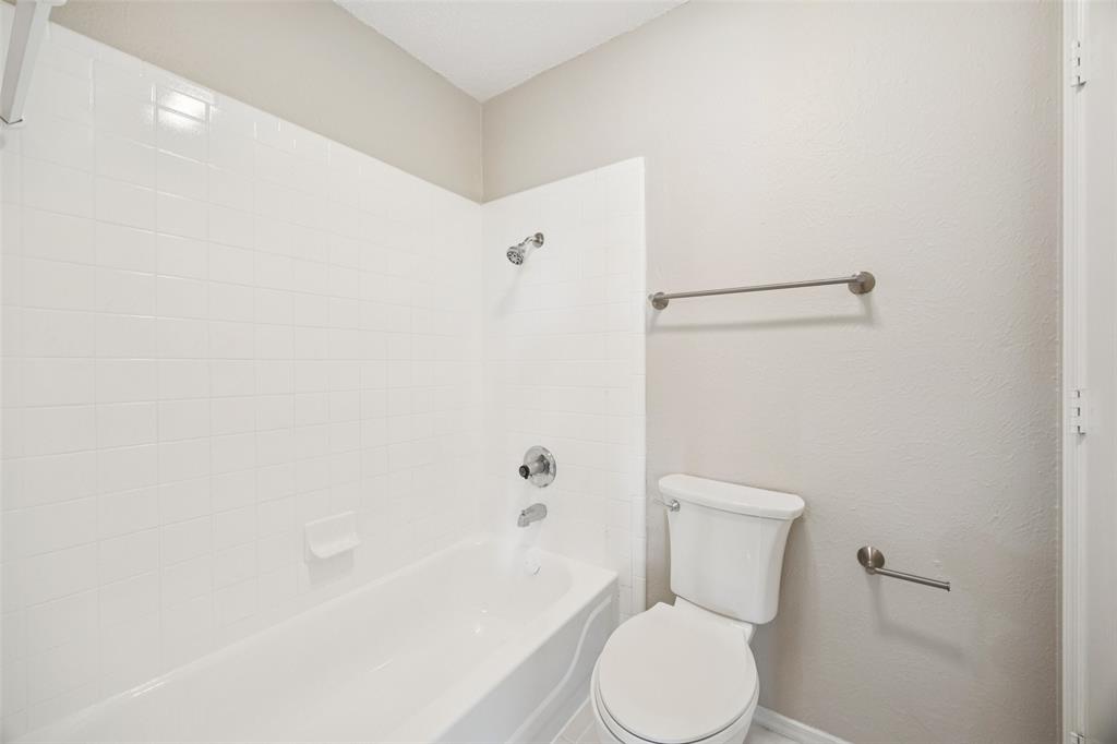 207 East Harwood Road, Unit 14 Euless, TX 76039 - Photo 20 of 28 a white toilet sitting next to a bath tub