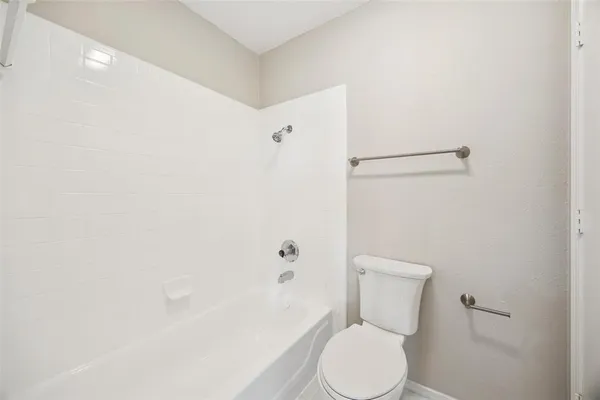 a white toilet sitting next to a bath tub