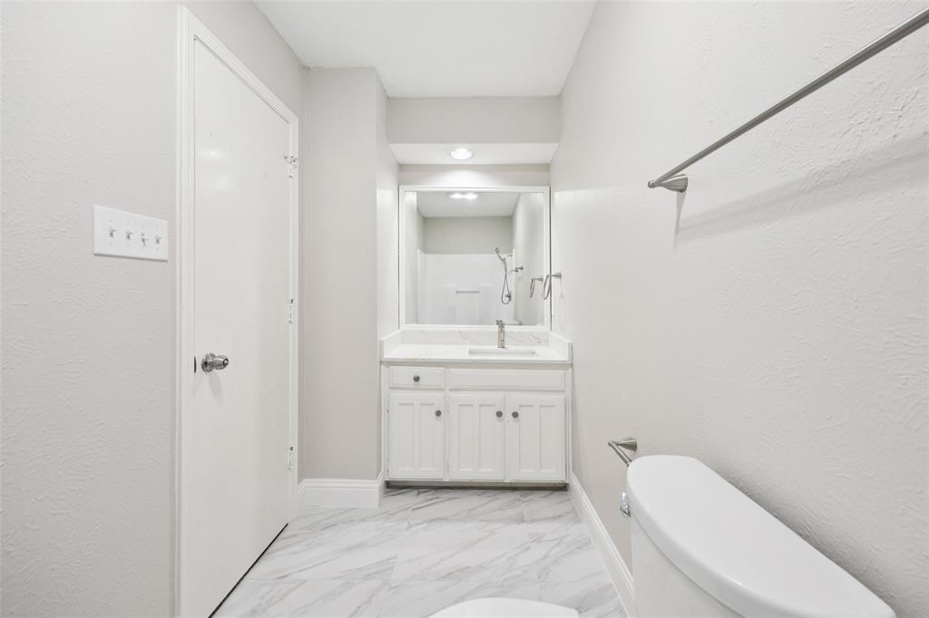 207 East Harwood Road, Unit 14 Euless, TX 76039 - Photo 26 of 28 a bathroom with a sink a toilet and shower
