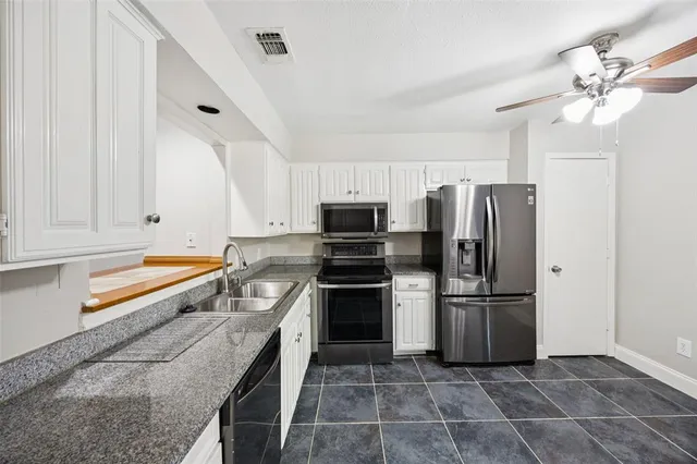 a kitchen with granite countertop a refrigerator and a sink