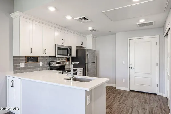 a kitchen with microwave a sink and refrigerator