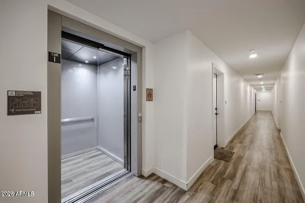 a view of a hallway with wooden floor and staircase