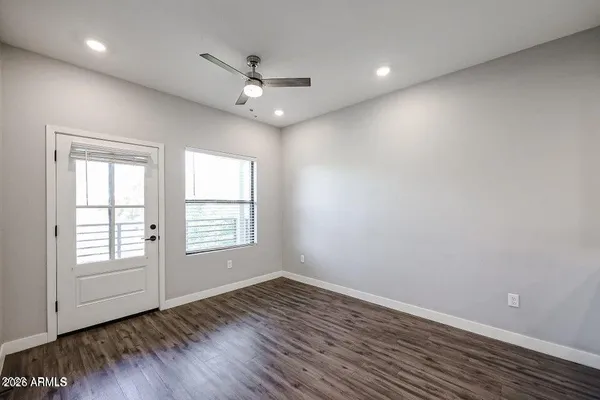 an empty room with wooden floor and windows