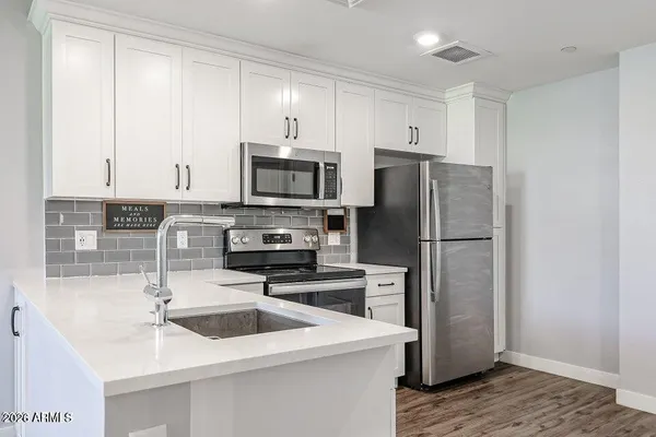 a kitchen with a sink a microwave a refrigerator and cabinets