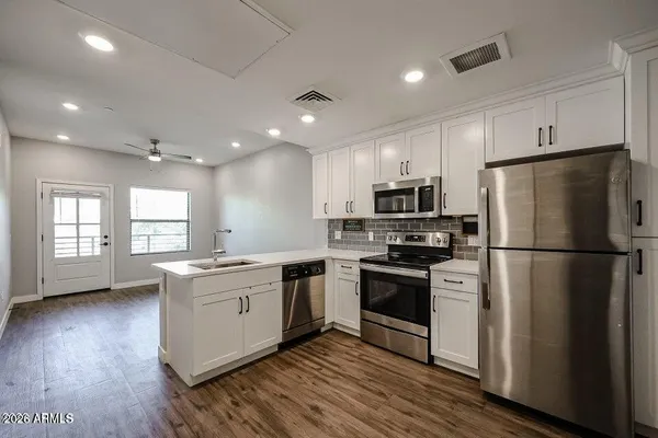 a kitchen with stainless steel appliances a refrigerator sink and microwave