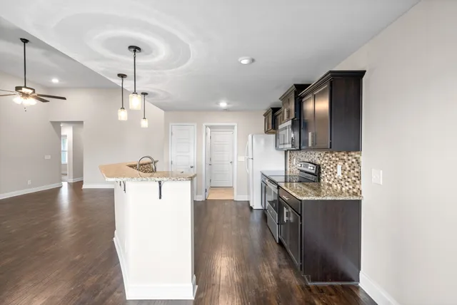 a kitchen with kitchen island a counter top space a sink and stainless steel appliances