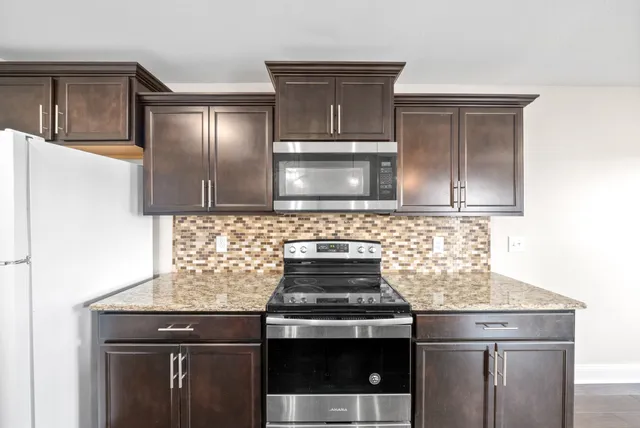 a stove top oven sitting inside of a kitchen