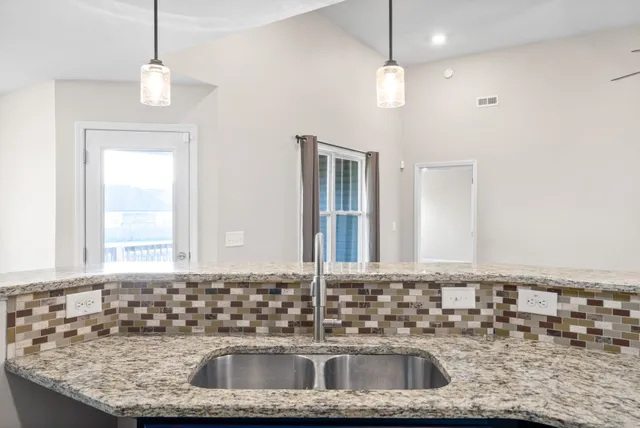 a bathroom with a granite countertop sink a mirror and window
