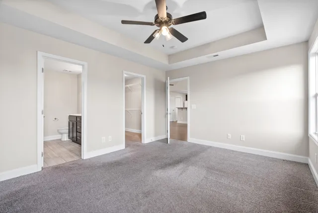 an empty room with closet and a ceiling fan
