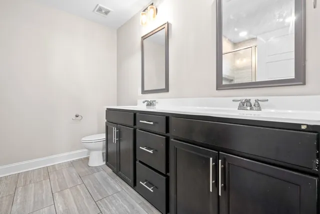 a bathroom with a sink a toilet a mirror and vanity