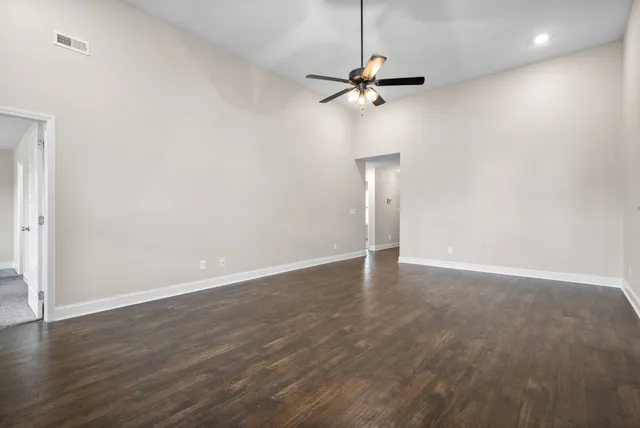 a view of an empty room with wooden floor
