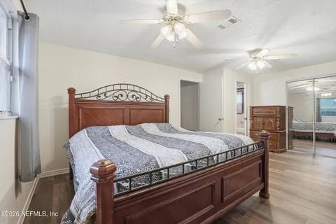 a bed sitting in a spacious bedroom next to a larger window