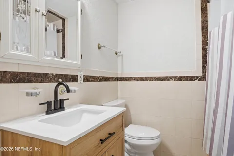 a bathroom with a sink a toilet and a mirror