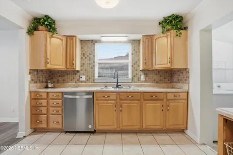 a kitchen with a sink window and cabinets