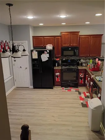 a kitchen with stainless steel appliances kitchen island granite countertop a refrigerator and a stove top oven