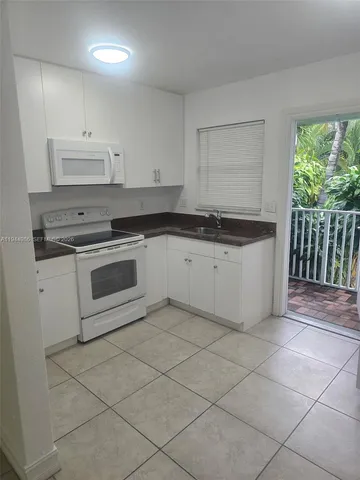 a kitchen with granite countertop a stove top oven sink and cabinets